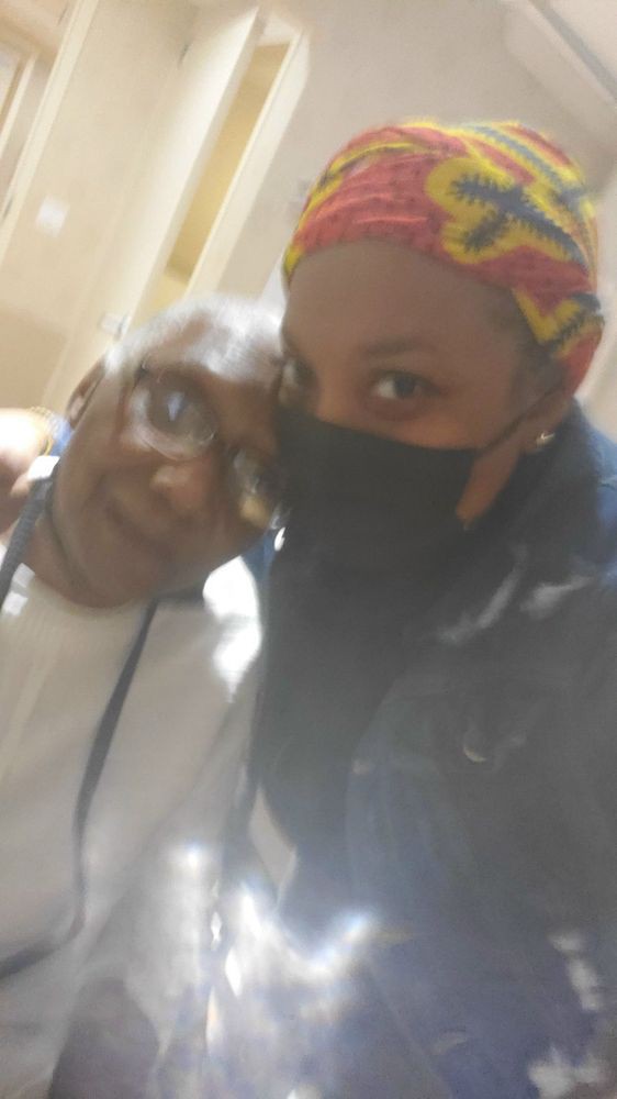 A selfie of two people, one wearing glasses and the other a mask.
