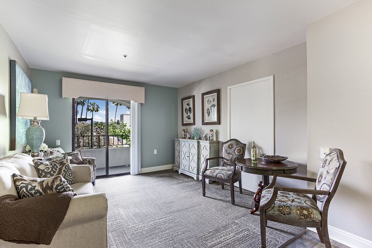 A cozy living room with elegant furniture and a view of the balcony.
