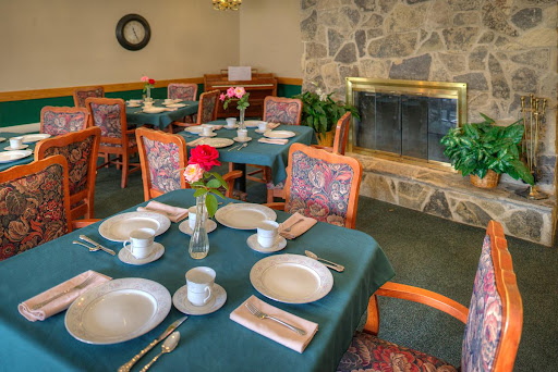 A cozy dining area set for a meal, featuring elegant table settings and a warm fireplace.