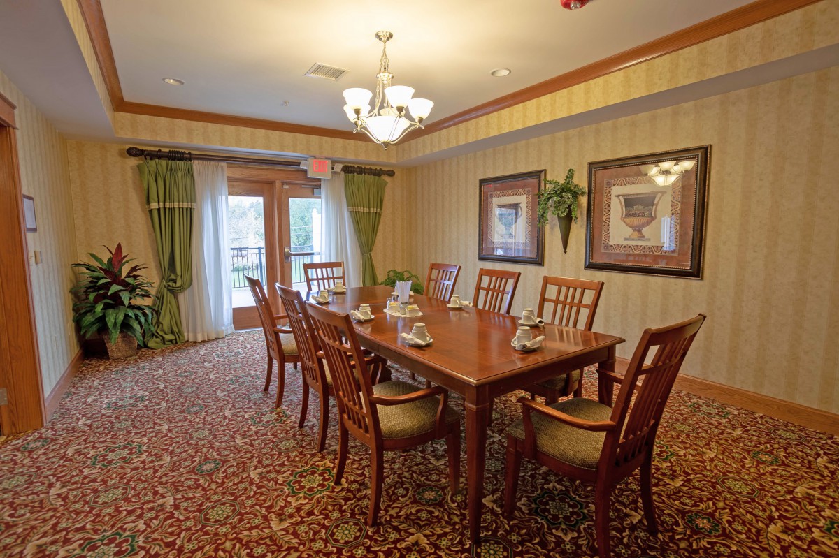 Elegant dining room with a wooden table and chairs, adorned with a chandelier and decorative artwork.