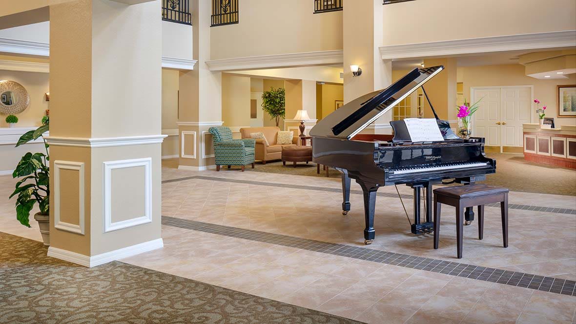A spacious lobby with a grand piano and comfortable seating area.