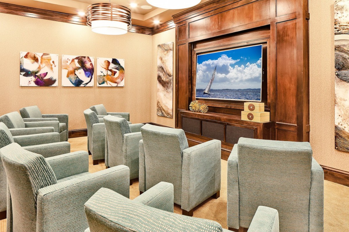A cozy home theater room with plush seating and a large screen TV.