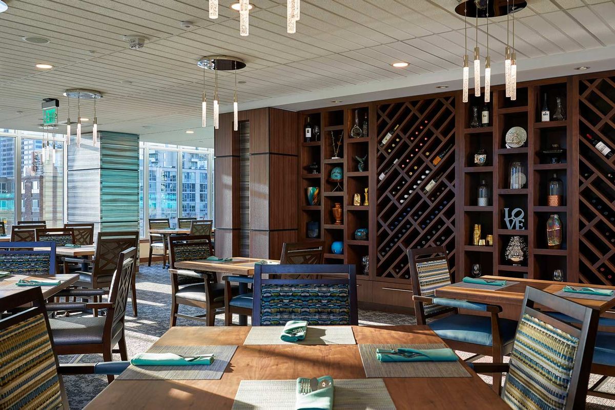A modern restaurant interior featuring wood accents and a stylish wine rack.