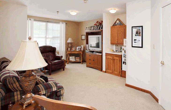 Cozy living room with a television, armchair, and bookshelf.