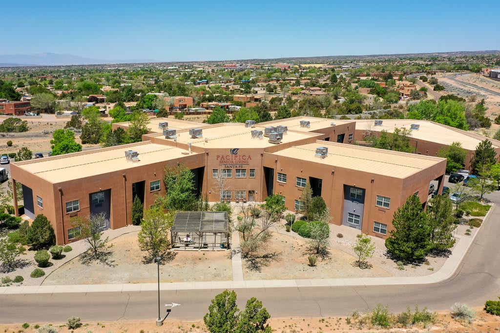 Aerial view of a modern building in a suburban desert landscape.