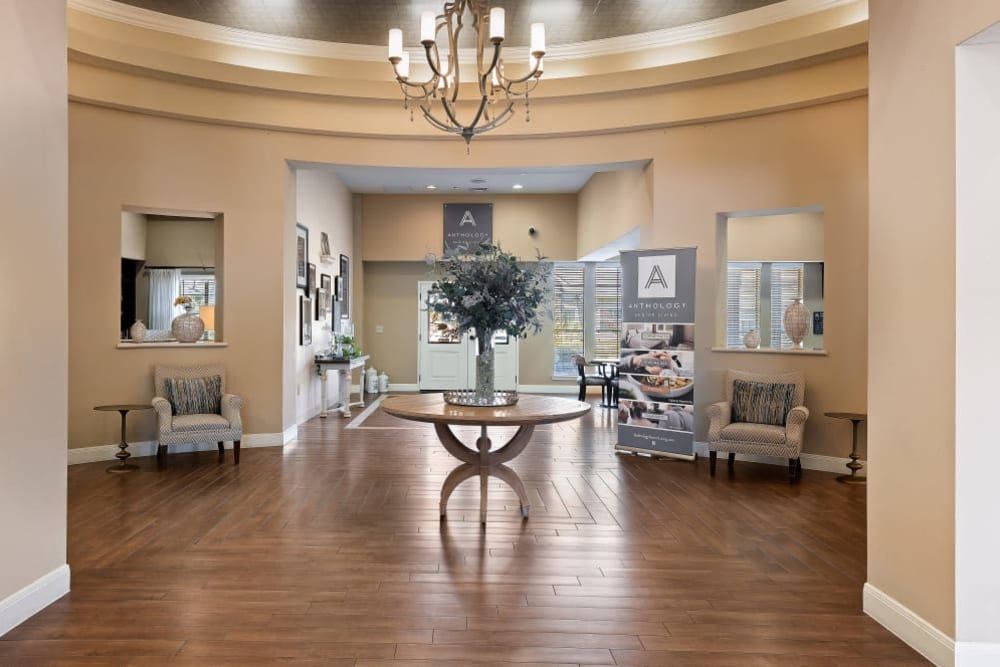 A spacious and elegantly designed lobby with a central table and chandelier lighting.