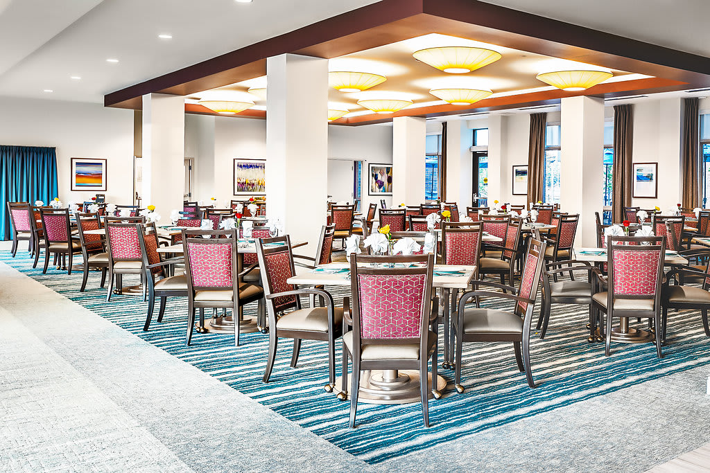 A modern dining area with neatly arranged tables and chairs, featuring elegant interior design.