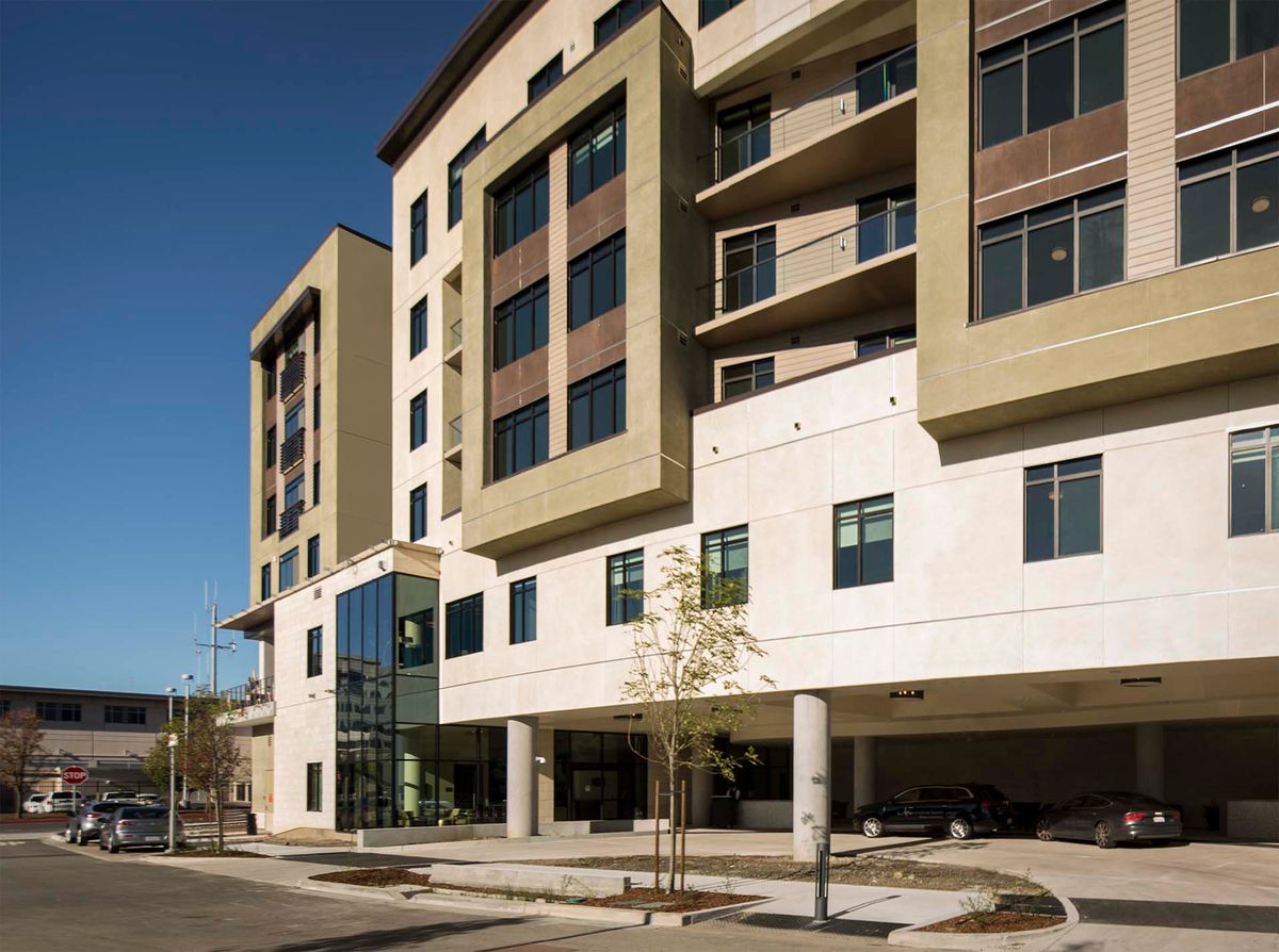 A modern apartment building with a multi-story design and large windows.