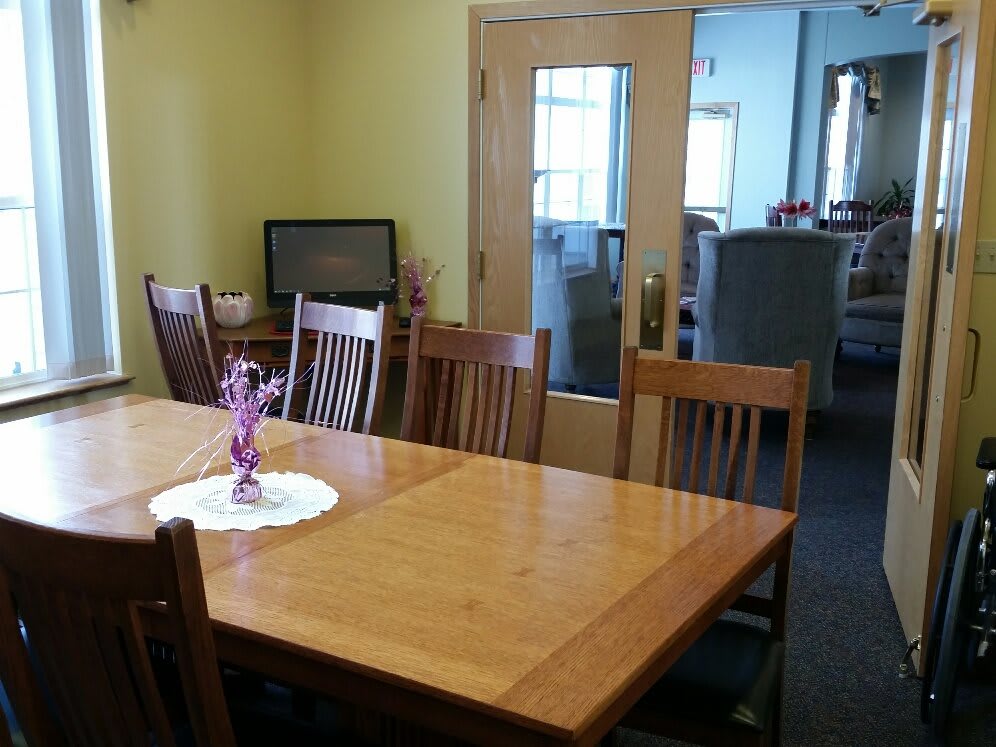 A cozy dining room featuring a wooden table set with chairs and a decorative centerpiece.