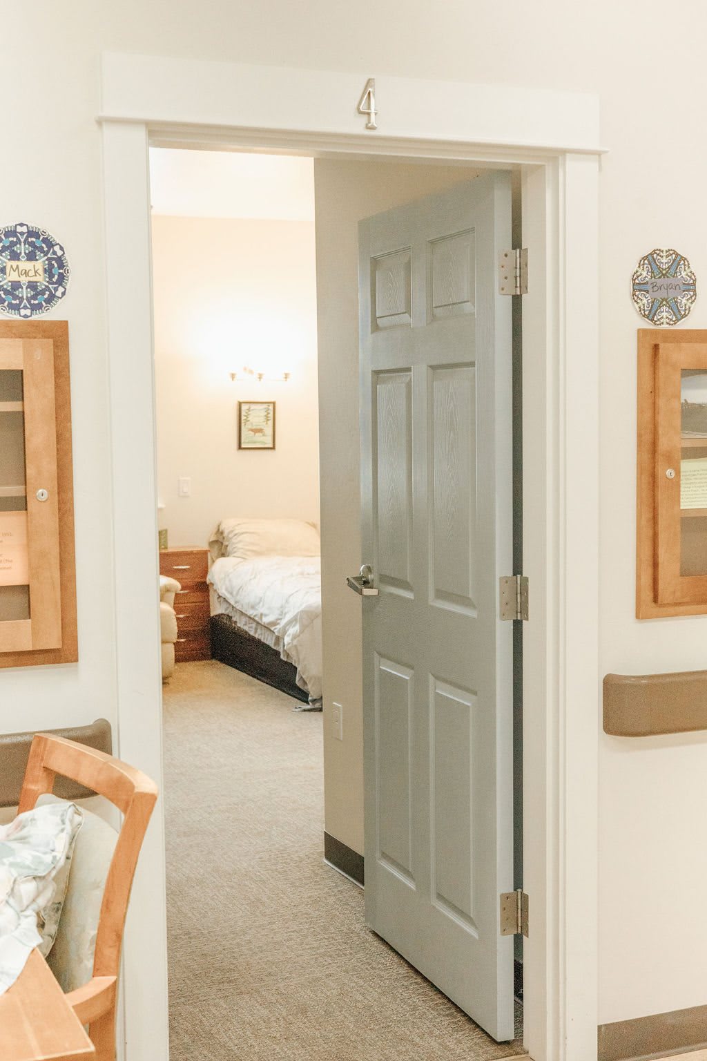 A view through an open doorway into a cozy and well-lit bedroom with simple furnishings.