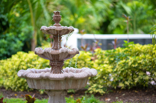 A beautiful stone fountain surrounded by lush greenery in a serene garden setting.