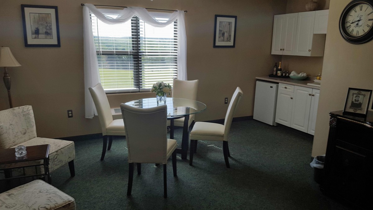 Bright dining area with a round table and four chairs near a window.
