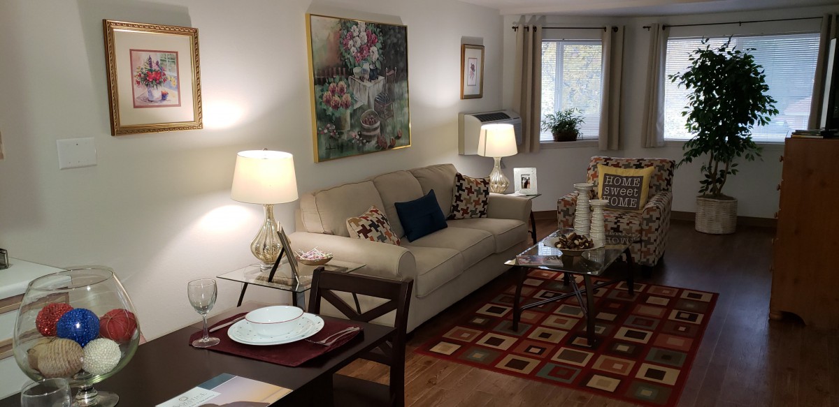 A cozy living room with a comfortable sofa, artwork on the wall, and warm lighting.