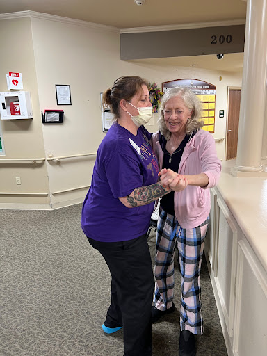 A joyful moment shared between a nurse and a patient in a hospital setting.