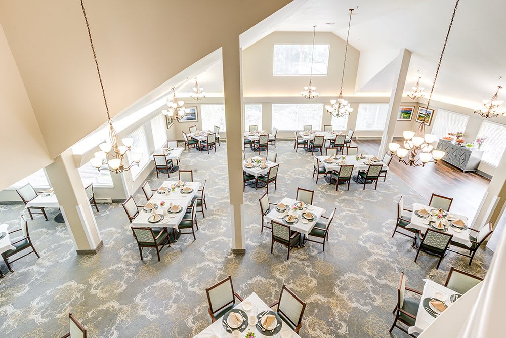 A spacious and well-lit dining area with neatly arranged tables and chairs.