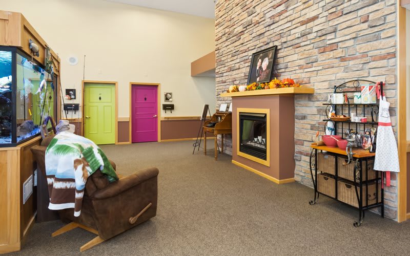 A cozy living room with a stone fireplace and colorful doors.