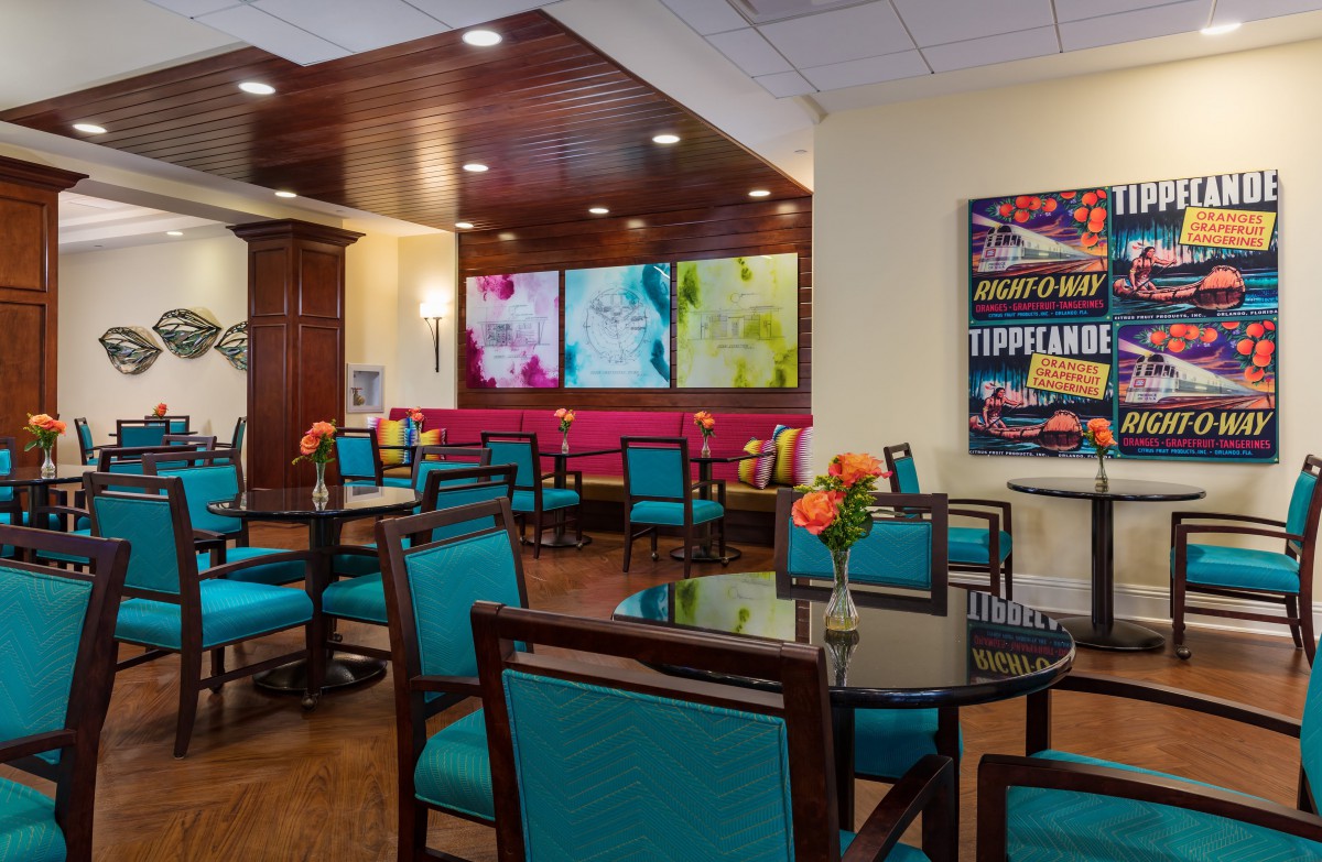 A modern dining area featuring colorful artwork and vibrant seating.