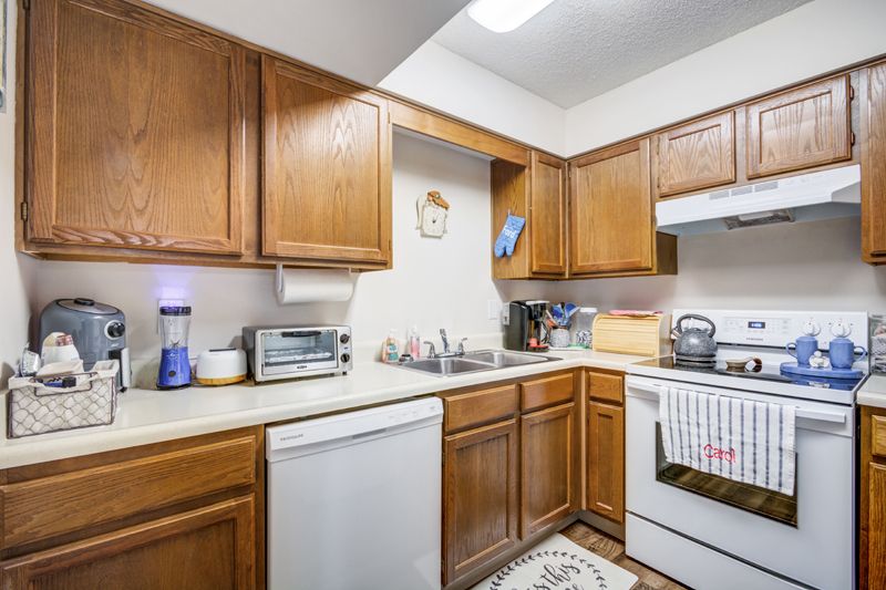 A cozy kitchen with wooden cabinets and various appliances.
