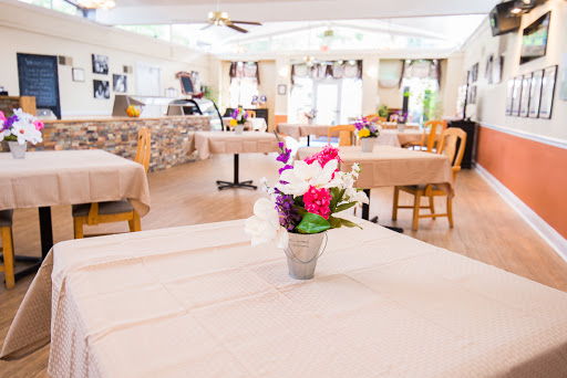 A tranquil dining area featuring neatly arranged tables and decorative flowers, perfect for a pleasant meal.