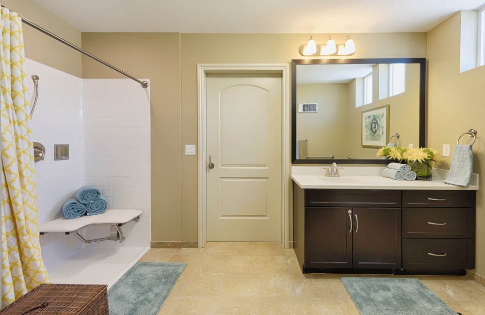 A modern bathroom with a bathtub, sink, and large mirror.