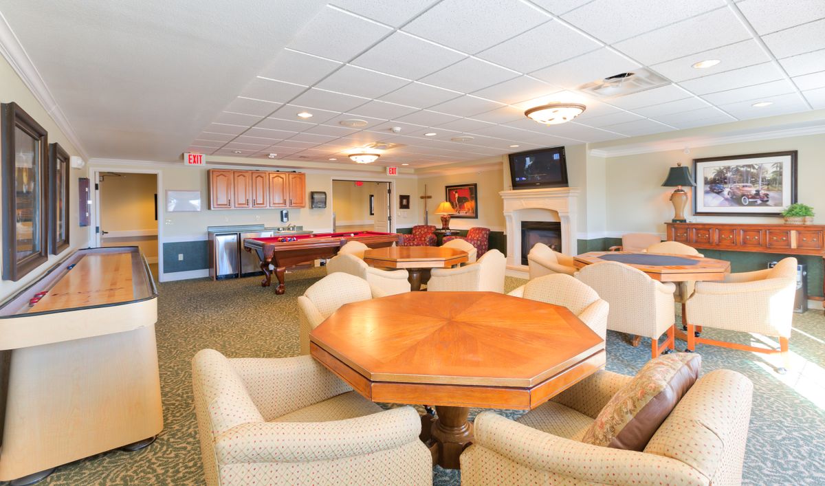 A cozy lounge area featuring a pool table, comfortable seating, and a fireplace.
