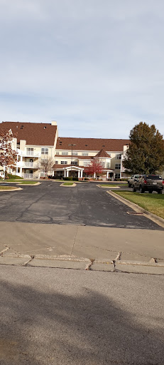 A view of a residential building with a parking area in front.