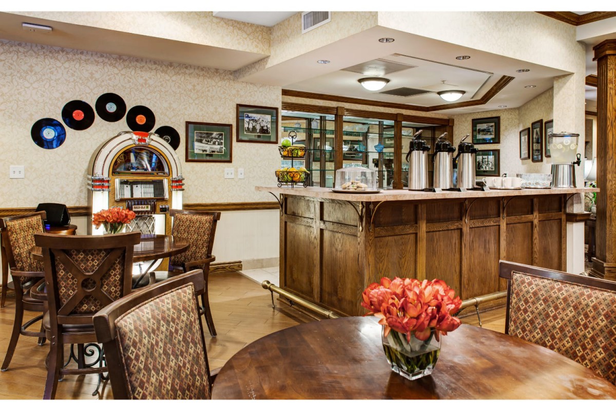 A cozy cafe interior featuring a jukebox and a bar area with coffee dispensers.