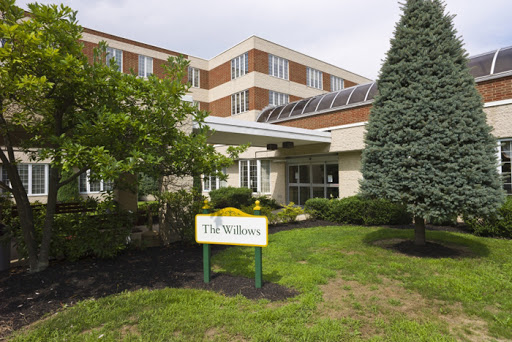 The exterior of a facility named 'The Willows', featuring landscaped grounds and modern architecture.