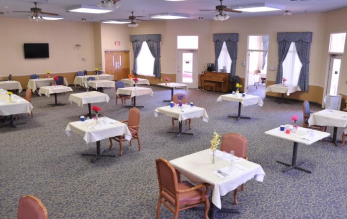 An empty dining room with neatly arranged tables and chairs.