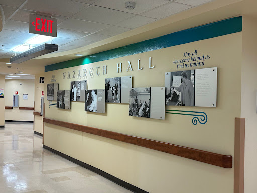 A hallway in a hospital showcasing a dedicated 'Research Hall' with framed photographs.