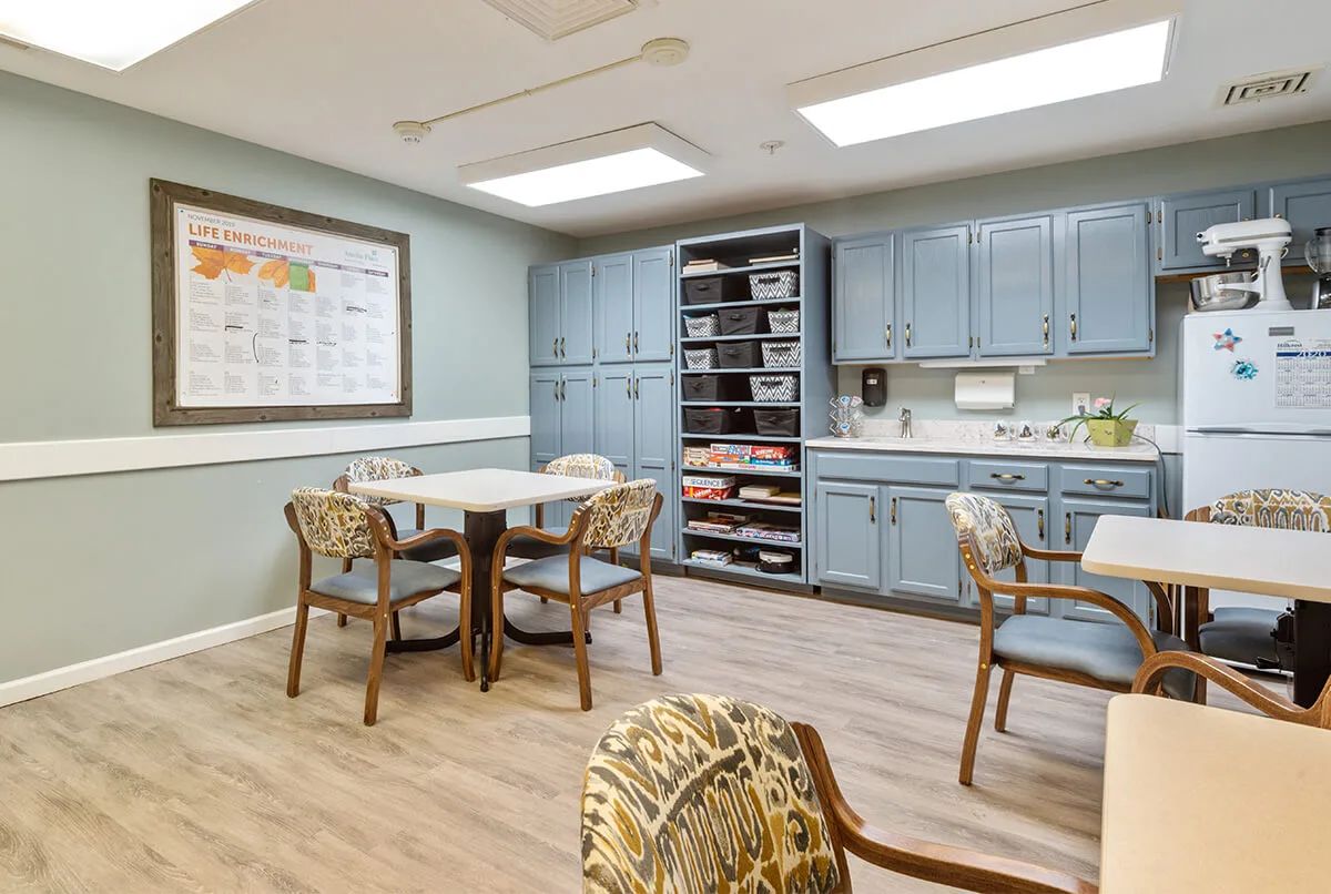 A cozy kitchen and dining area with light blue cabinets, a table, and chairs.