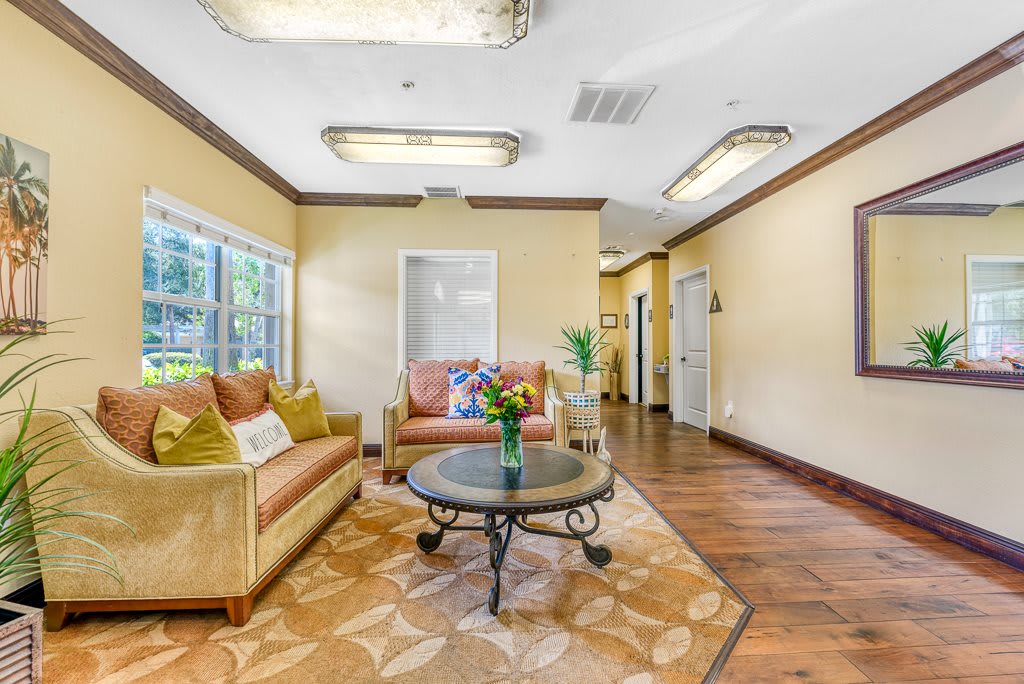 A cozy living room with comfortable sofas, a round coffee table, and large windows providing natural light.
