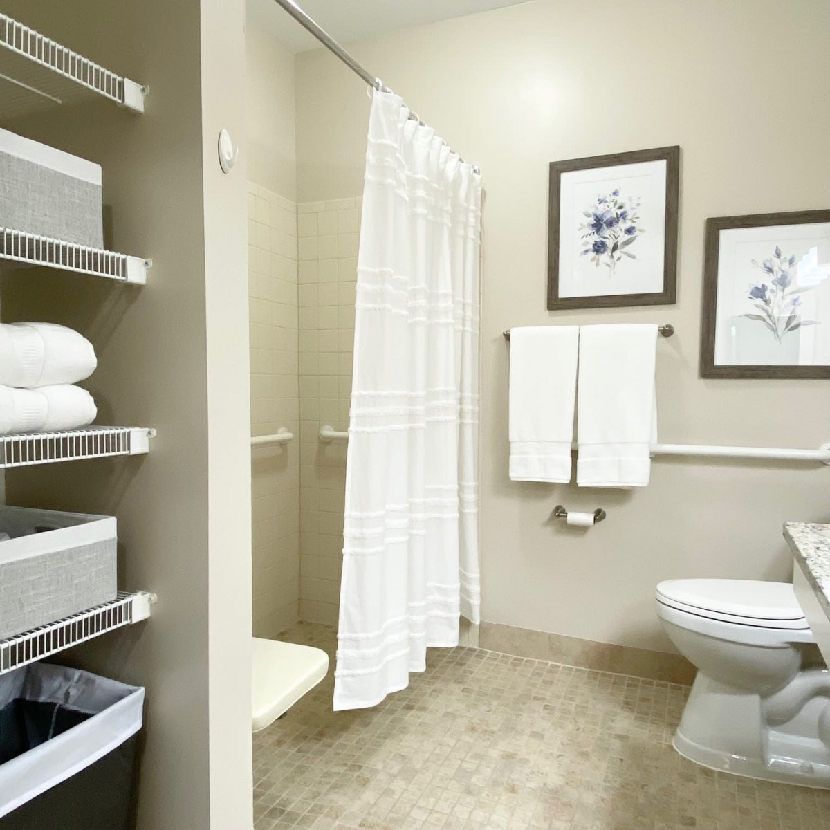 A modern bathroom with a shower, toilet, and neatly arranged towels.