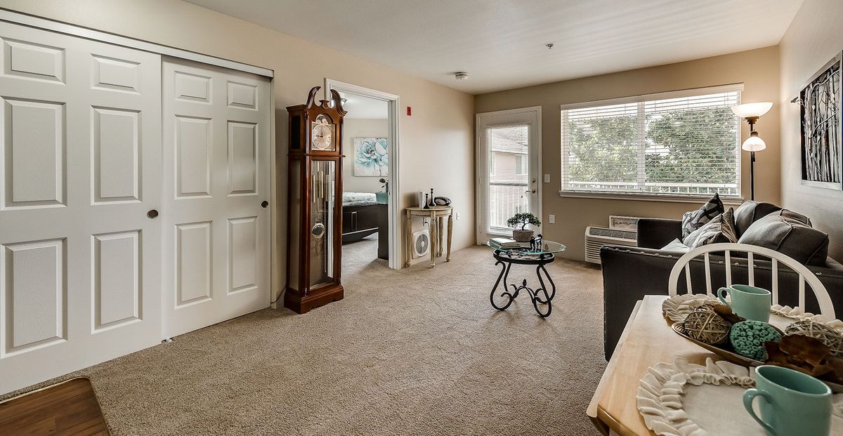 A cozy living room featuring a grandfather clock and warm neutral tones.