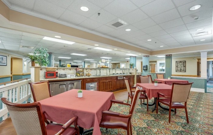 A spacious dining area with tables and chairs, featuring a warm interior design.
