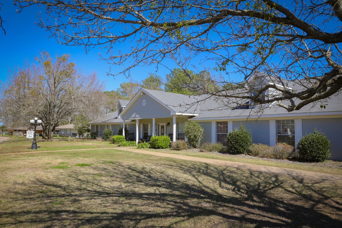 A suburban house with a spacious yard under a clear blue sky.
