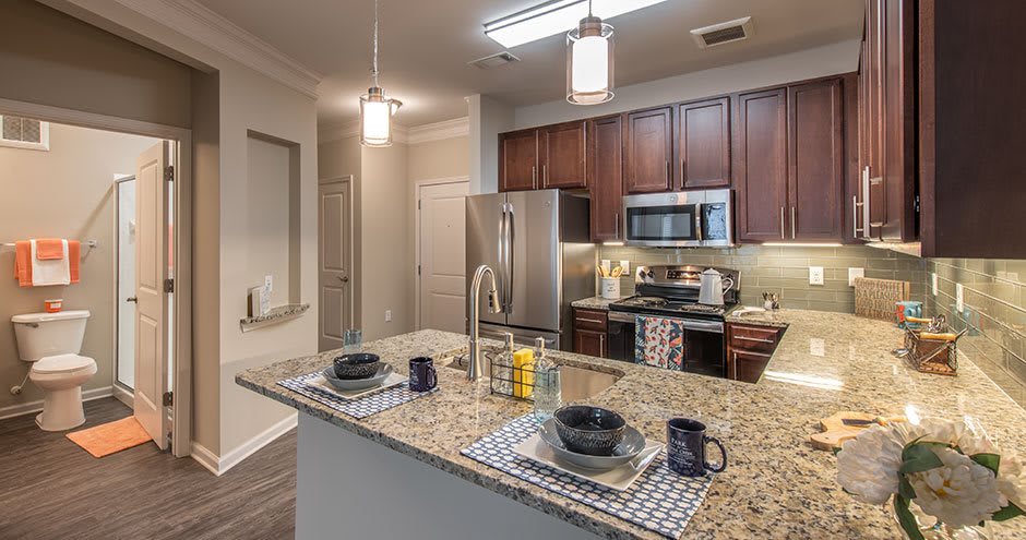 A modern kitchen with granite countertops and stainless steel appliances.