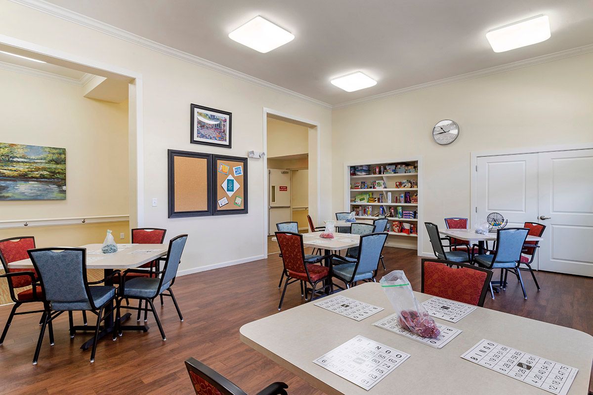 A well-lit community room with organized tables and chairs, featuring decorations and ample space for gatherings.
