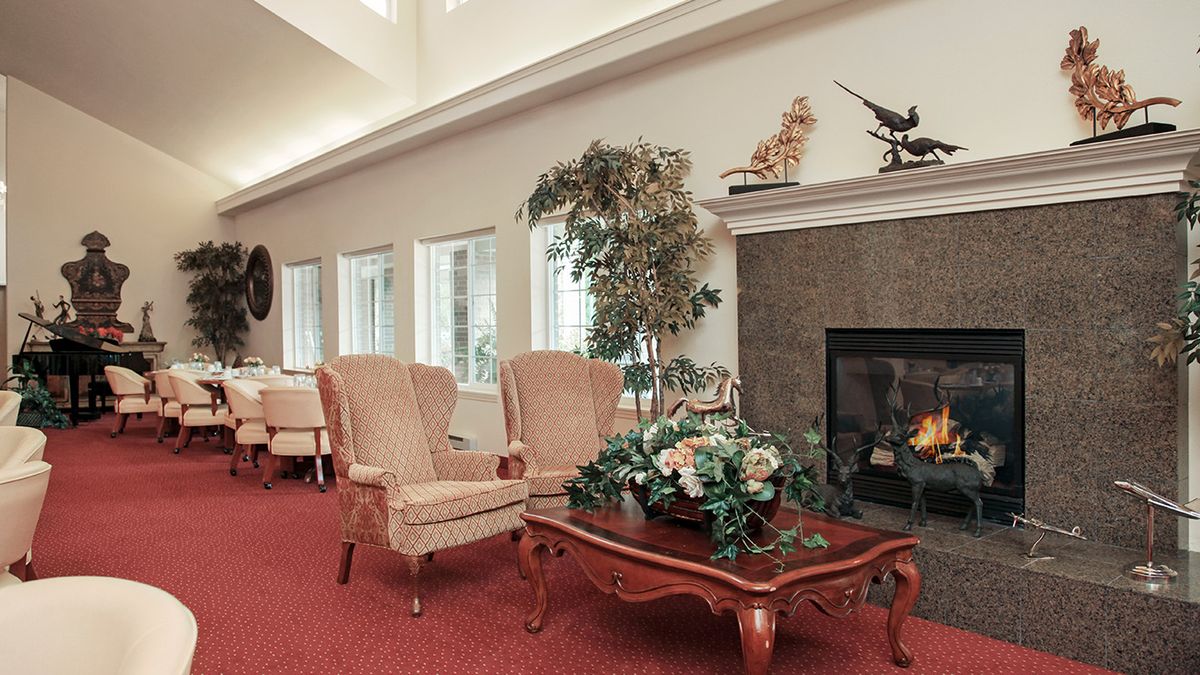 A cozy living room with elegant armchairs, a coffee table, and a fireplace.
