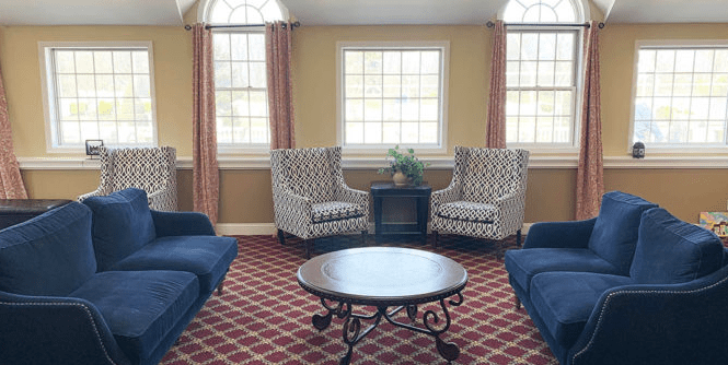 A cozy living room with patterned armchairs and a round coffee table.