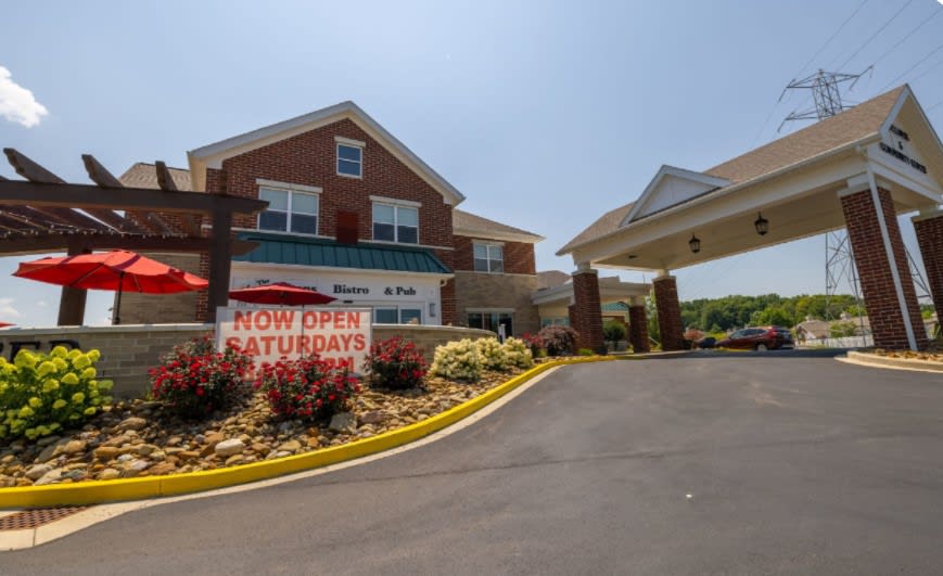 A hotel entrance with a visible banner reading 'Now Open Saturdays'.