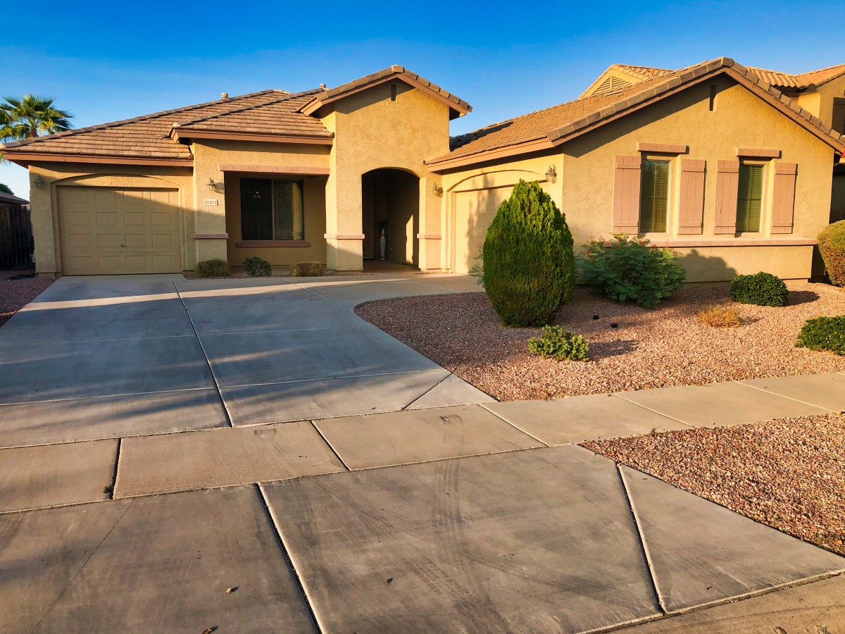 A single-story suburban house with desert landscaping and a spacious driveway.