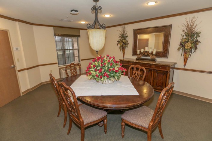 Elegant dining room with a wooden table and decorative flowers.