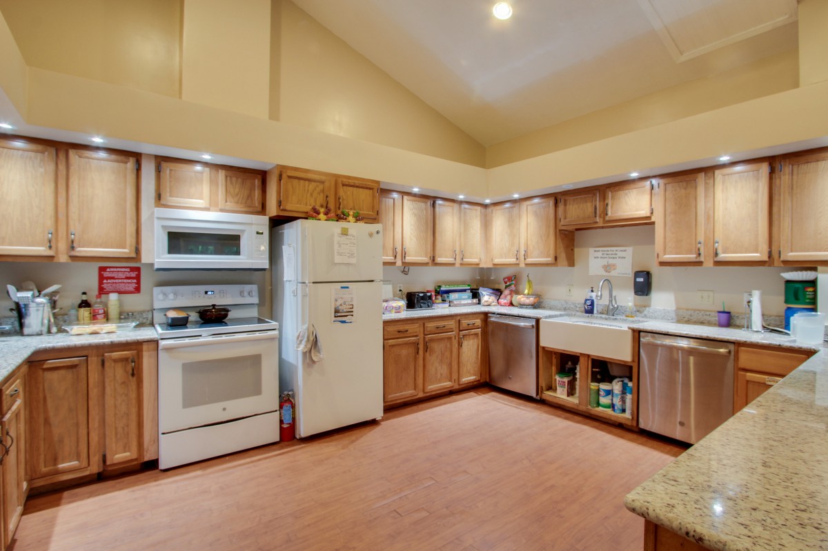 A spacious kitchen with wooden cabinets and modern appliances.