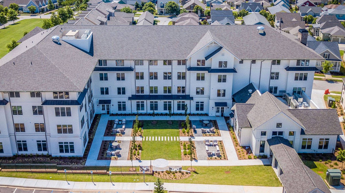 Aerial view of a large, multi-story residential building with a landscaped courtyard.