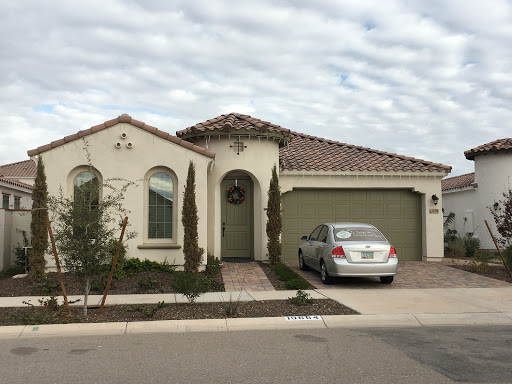 A charming residential house with a garage and landscaped front yard.