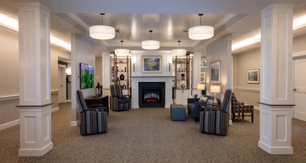 A modern living room with comfortable seating, a central fireplace, and stylish lighting.