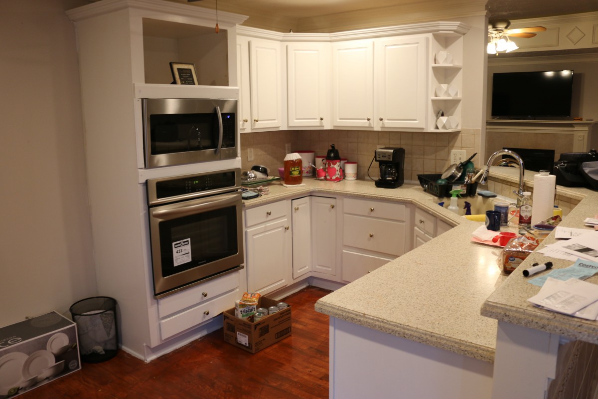 A cozy kitchen with white cabinets and modern appliances.