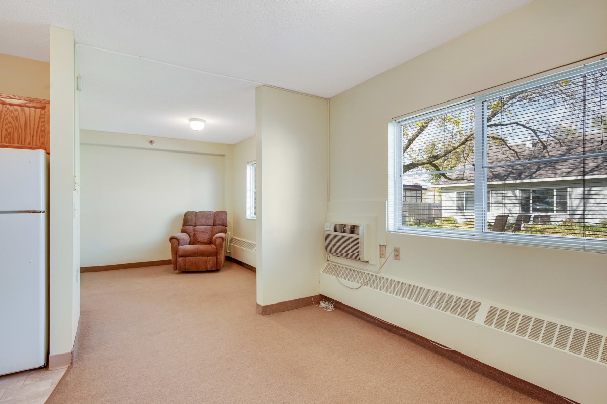 A minimalist living room with a single chair and large windows.