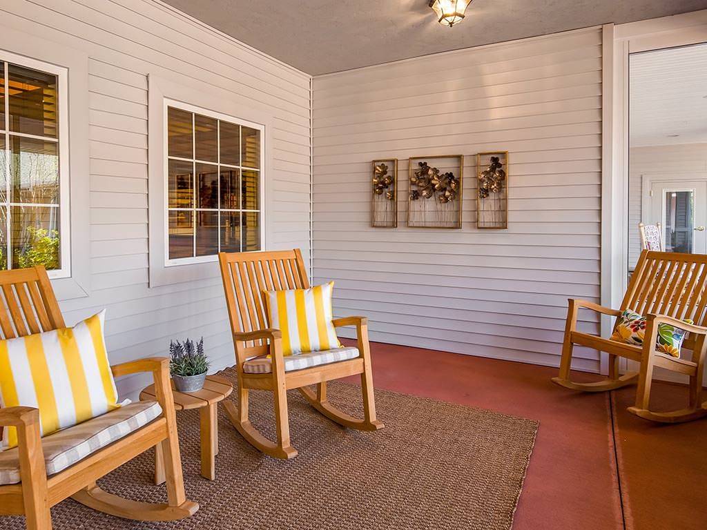 A cozy porch area featuring wooden rocking chairs and decorative elements.